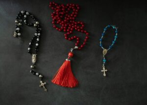 Flat lay of decorative rosaries and prayer beads on a dark background, highlighting spirituality and faith.